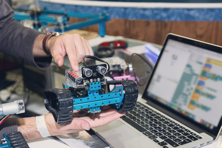 Model of a robot in the hands of a teacher during a robotics lesson. Diyの写真素材