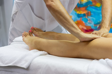 Hands of the masseur and the client's feet during a massage treatment. Medicineの写真素材
