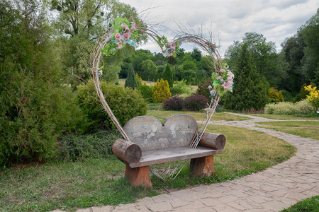Beautiful wooden park bench stylized in the form of a heart for lovers and newlywedsの写真素材