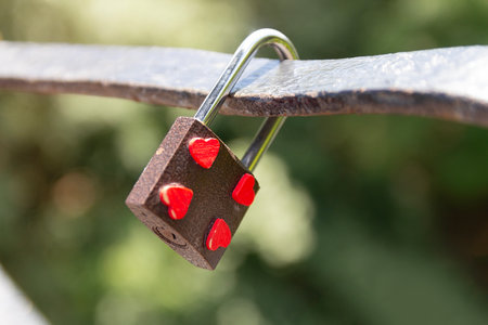 Padlock on a bridge depicting hearts.