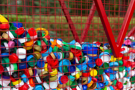 A lot of small colorful bottle caps in a container for collecting secondary raw materials. Industryの写真素材