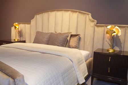 Luxurious bedroom in beige tones with a bed and bedside tables. Interiorの写真素材