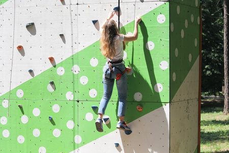Girl climbing to big artificial wall. Sportの写真素材