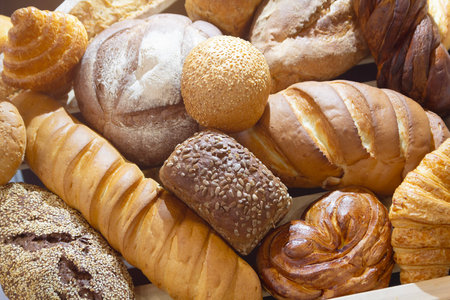 Assorted fresh bread varieties displayed artfully on a neutral background, showing textures. Foodの写真素材
