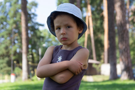 Portrait of a serious child in the summer among trees in the park. Peopleの写真素材