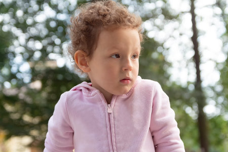 Portrait of a pretty curly child in the park. Peopleの写真素材