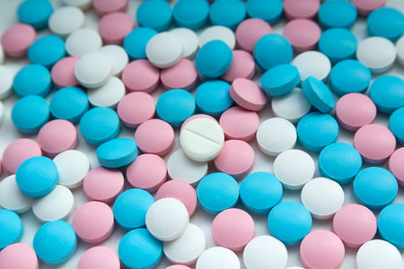 White, blue and pink tablets scattering on the table. Backgroundの写真素材