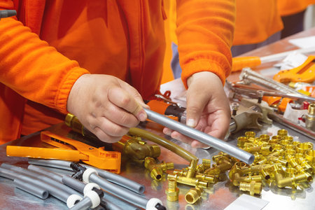 Master demonstrates components for installation of cross-linked polyethylene water pipes. Industry
