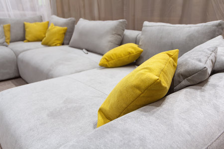 Interior of living room with yellow pillow in gray sofa against wall backgroundの写真素材