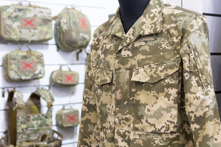 Mannequin dressed in camouflage attire and tactical gear on display in military storeの写真素材