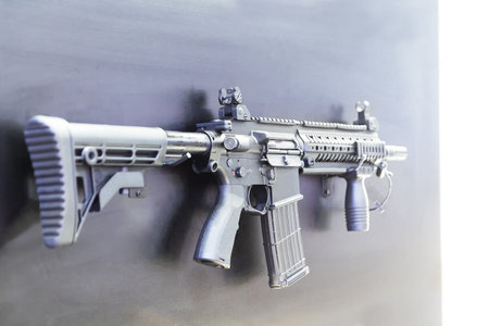 Automatic rifle with a high grenade launcher on the window of the weapon store close-up