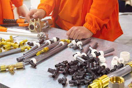 Master demonstrates components for installation of cross-linked polyethylene water pipes. Industryの写真素材