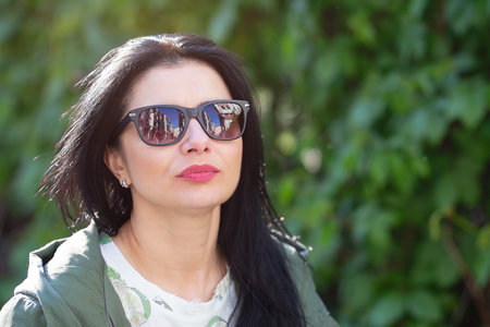 Woman wearing sunglasses in the garden. Peopleの写真素材