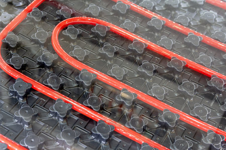 Red pipes laid out in a grid pattern for a radiant heating system. Industryの写真素材