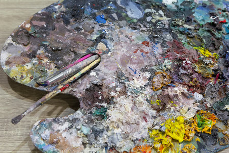 Vibrant artist's palette with various colorful paint blobs and a brush, perfect for creative projectsの写真素材