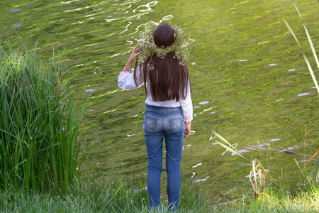Girl in a wreath of grasses by the river. The national Slavic holiday of Ivan Kupalaの写真素材