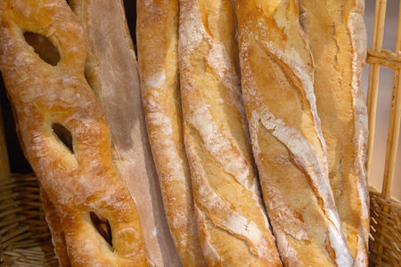 The baguettes are arranged on shelves and is ready to be sold. Food
