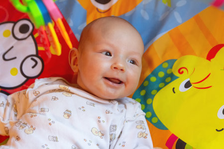 Happy baby lying on a play mat.の写真素材