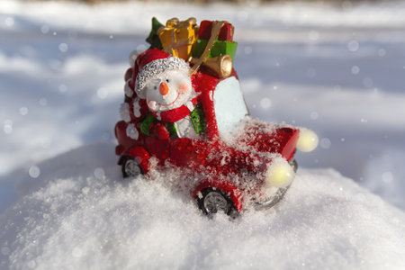 Cheerful toy snowman on a car carries gifts. Christmas toyの写真素材