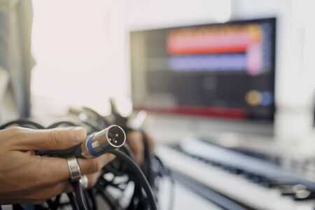 Doesnt know what to do with wires and cords and cables. DJ in broadcasting studio. music producer is composing a song on synthesizer keyboard and computer in recording studioの写真素材