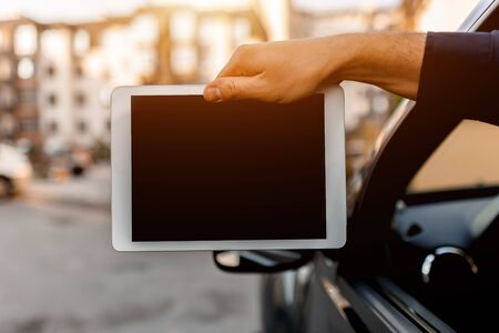A driver shows a tablet pc screen close-up into the camera. Empty space for your text or graphics.の写真素材