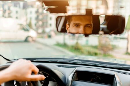 A man looks out the rear view window. In his car. Transportation conceptの写真素材