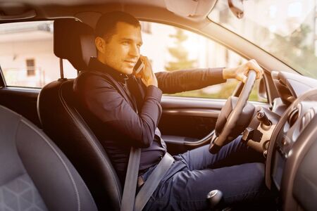 A man is sitting in a car. Vehicle interior. Businessman driving.
