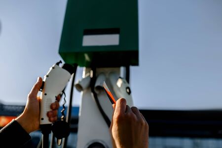 Charging station for electric vehicle. Close-up of charger and credit cardの写真素材