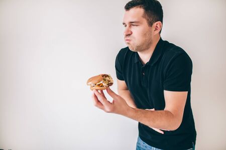 Young man isolated over white background. Sick guy suffer from vomit because of bad unhealthy unfresh burger. Almost vomiting.の写真素材