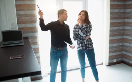 Realtor, broker or landlord shows an apartment to a young woman. She is going to sign a lease...