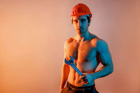 Young european worker man in helmet with wrenchの写真素材
