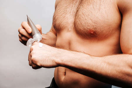 Cropped image of man apply cosmetic cream on handの写真素材