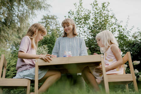 Mother is painting with her children in the gardenの写真素材