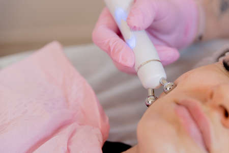 apparatus massager ultrasonic rf lifting in the hand of a beautician in a glove . Cosmetic apparatus...