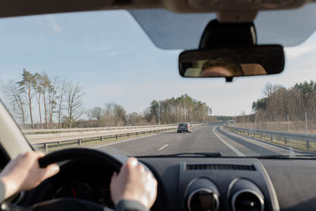 Generic photo of man driving a car through slight turn. man drivingの写真素材