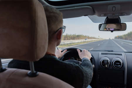 Generic photo of man driving a car through slight turn. man drivingの写真素材