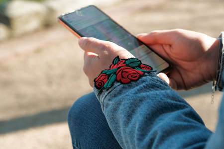 Woman with mobile phone, outdoors. girl sitting on a bench and holding a phone