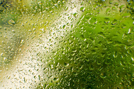 water drops on glass. water flows down the glassの写真素材