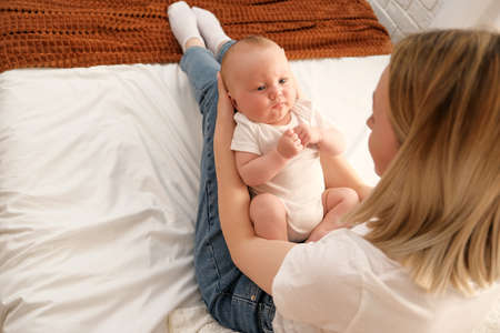 newborn baby in mom's arms. in the background the light from the window .the concept of mother's...