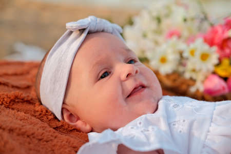 newborn baby girl lies on the beach. in a white dress.の写真素材