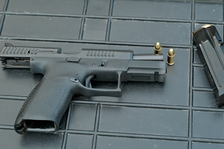 the pistol lies on the table 9 mm. the gun is on the cartridges. military weapons