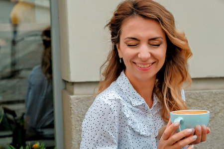 girl drinking coffee on the street. street cafe. beautiful girl and coffee.の写真素材