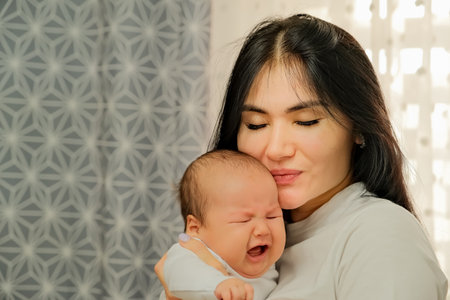 the girl is holding a newborn baby. newborn baby crying