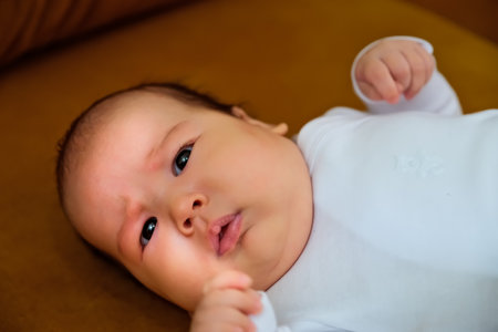 newborn baby lies on the dewan. newborn baby shows different emotionsの写真素材