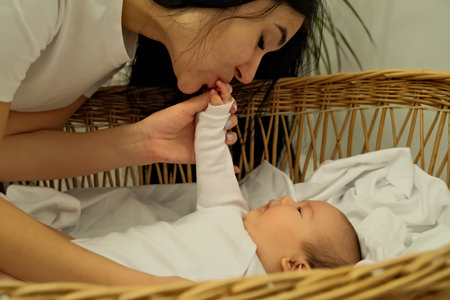 mother kisses the hand of a newborn. the concept of a kiss, motherly love.