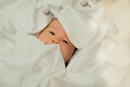 newborn baby smiles and laughs. shows emotions. baby lies on a white cloth