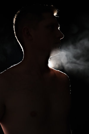 silhouette of a guy. men in the dark. smoke. steam. man in a dark room.の写真素材