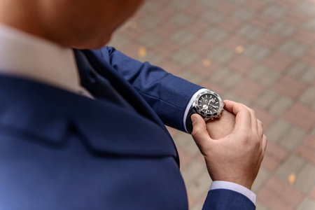 A man in a suit is checking his watch.の写真素材