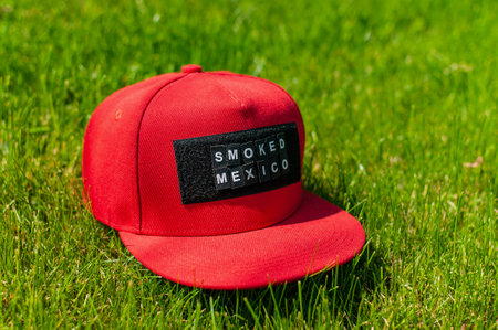 Red baseball cap on green grass.