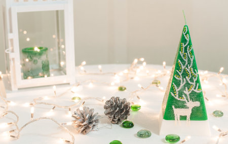 Christmas decoration on a white table with garland and candles.の写真素材